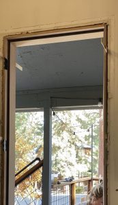 A door frame with shims placed between the house frame and door frame